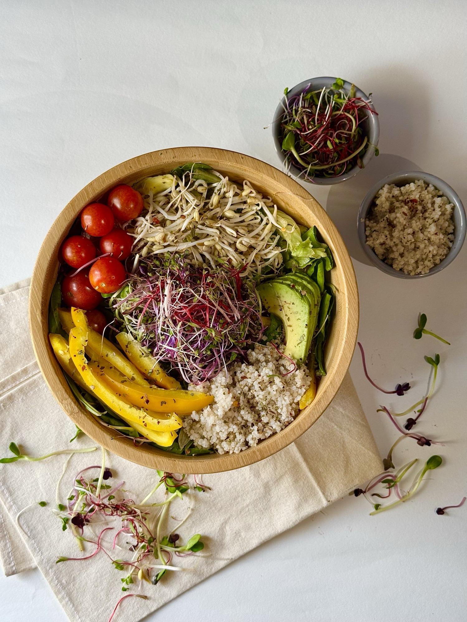 A fresh buddha bowl topped generously with Gutsee microgreens